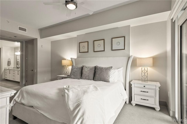 bedroom with ensuite bath, visible vents, and light colored carpet