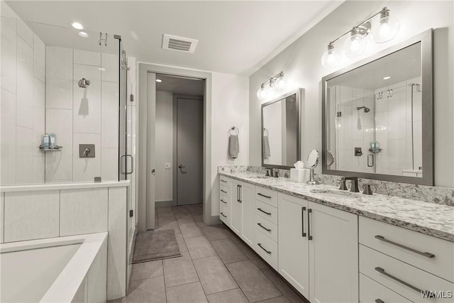 bathroom featuring double vanity, visible vents, tile patterned floors, a shower stall, and a sink