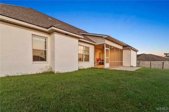 13862 Willow View Ln, Northport, AL 35475 - back of property at dusk with a sunroom and a ceiling fan
