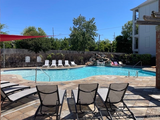 view of pool featuring pool water feature and a patio