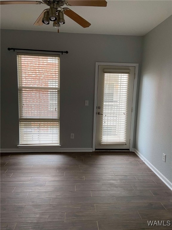 empty room featuring ceiling fan, a healthy amount of sunlight, and wood-type flooring