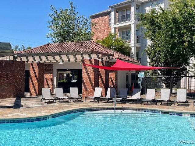 rear view of house featuring a community pool and a patio