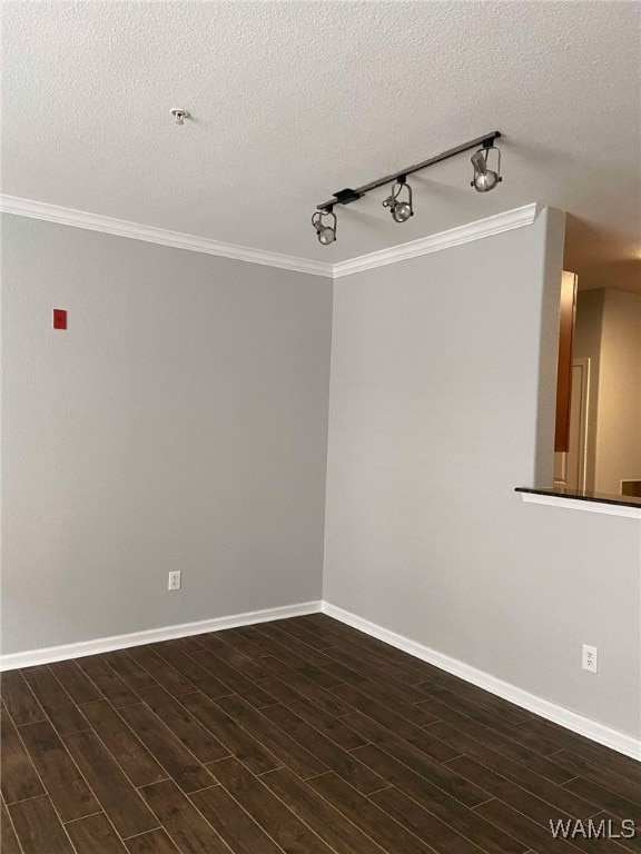 unfurnished room featuring track lighting, dark wood-type flooring, crown molding, and a textured ceiling