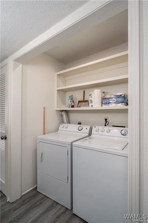 laundry area featuring dark hardwood / wood-style floors, washing machine and dryer, and a textured ceiling