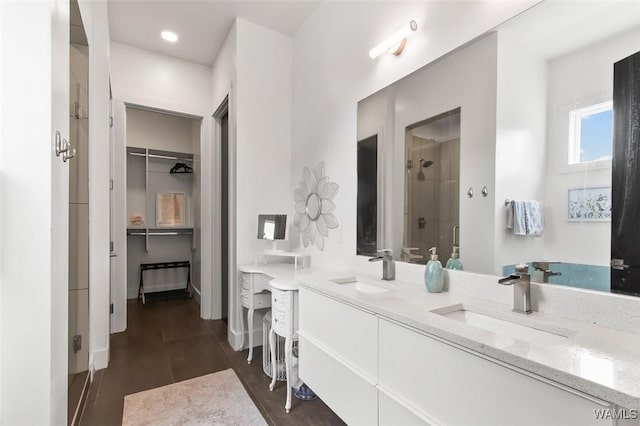 1038 14th Ave Unit B, Tuscaloosa, AL 35401 - bathroom featuring a shower stall, a walk in closet, and double vanity