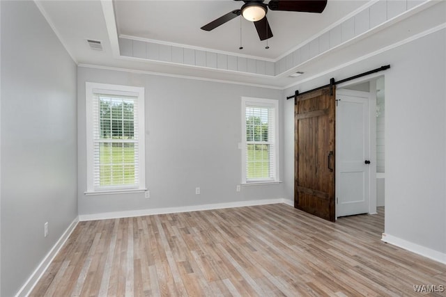 11376 Kings Loop Rd, Tuscaloosa, AL 35405 - unfurnished bedroom with a barn door, light wood-style floors, crown molding, a raised ceiling, and a ceiling fan