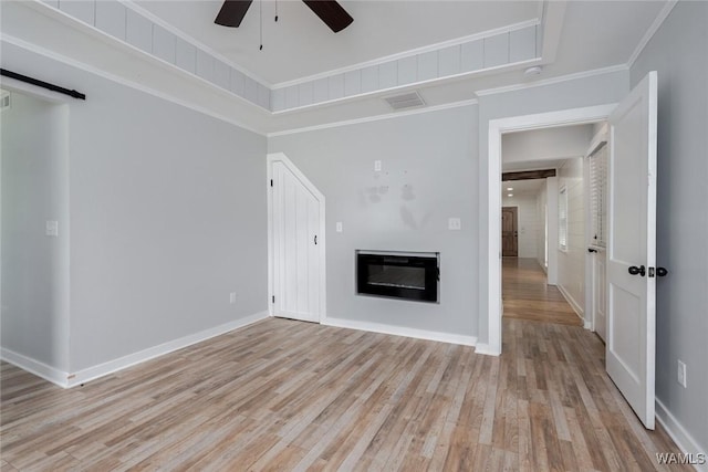 11376 Kings Loop Rd, Tuscaloosa, AL 35405 - unfurnished living room with ceiling fan, light wood-style flooring, a glass covered fireplace, and crown molding