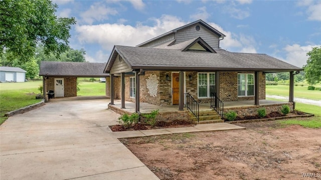 11376 Kings Loop Rd, Tuscaloosa, AL 35405 - view of front of property featuring concrete driveway, a front lawn, brick siding, covered porch, and roof with shingles