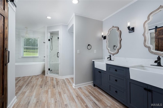 11376 Kings Loop Rd, Tuscaloosa, AL 35405 - bathroom featuring crown molding, double vanity, a stall shower, a soaking tub, and wood finished floors