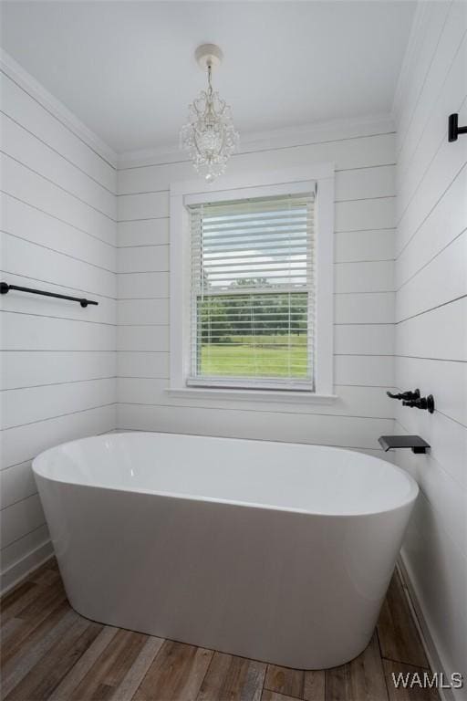 11376 Kings Loop Rd, Tuscaloosa, AL 35405 - bathroom with ornamental molding, a chandelier, a freestanding tub, wood finished floors, and wood walls