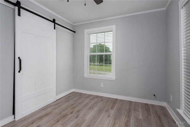 11376 Kings Loop Rd, Tuscaloosa, AL 35405 - unfurnished bedroom with a barn door, wood finished floors, ornamental molding, and ceiling fan