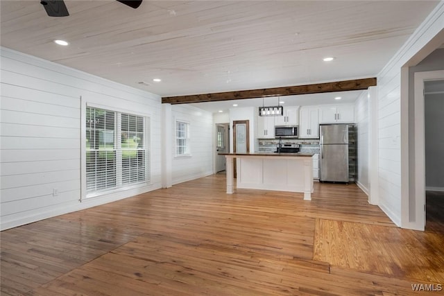 11376 Kings Loop Rd, Tuscaloosa, AL 35405 - kitchen featuring appliances with stainless steel finishes, white cabinetry, light wood-style flooring, open floor plan, and beamed ceiling