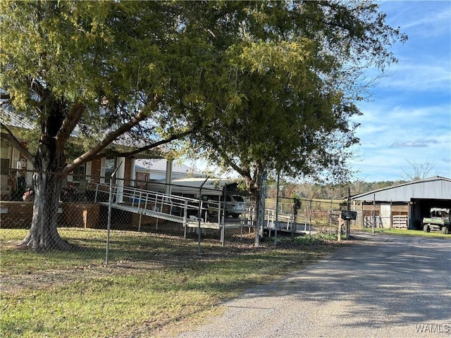 exterior space featuring gravel driveway, fence, and an outdoor structure