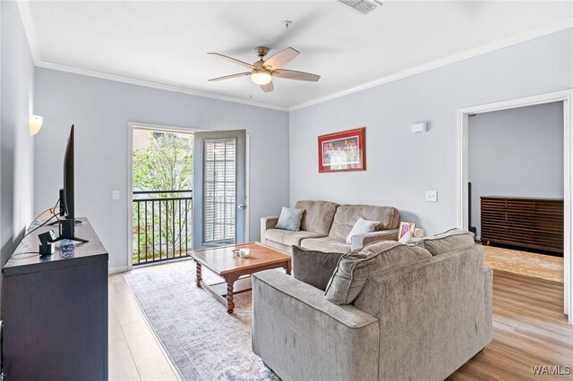 living room featuring ceiling fan, crown molding, and light wood-type flooring