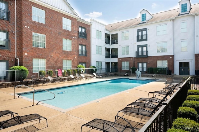 pool featuring fence and a patio area