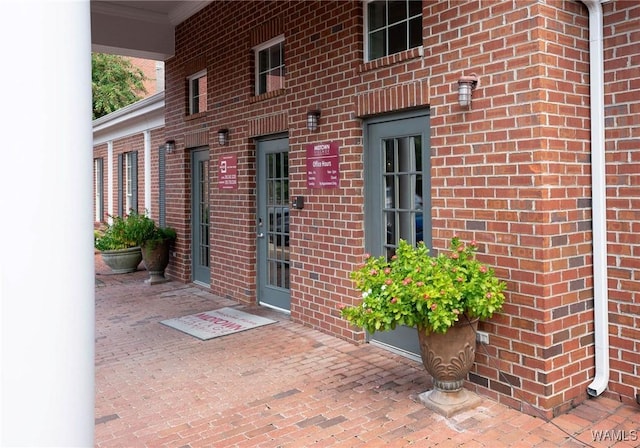 doorway to property featuring brick siding