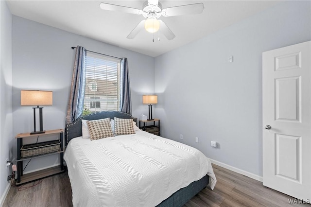 bedroom with wood finished floors, a ceiling fan, and baseboards