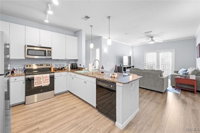 kitchen with white cabinets, a sink, a peninsula, appliances with stainless steel finishes, and open floor plan