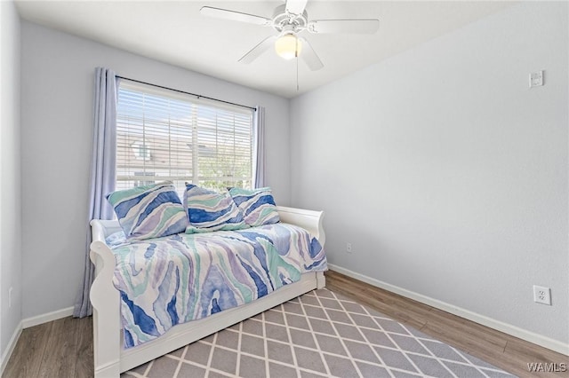 bedroom featuring wood finished floors, a ceiling fan, and baseboards