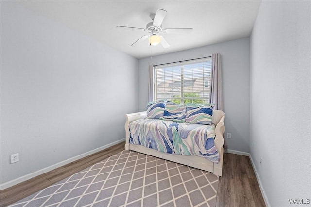bedroom featuring wood finished floors, a ceiling fan, and baseboards
