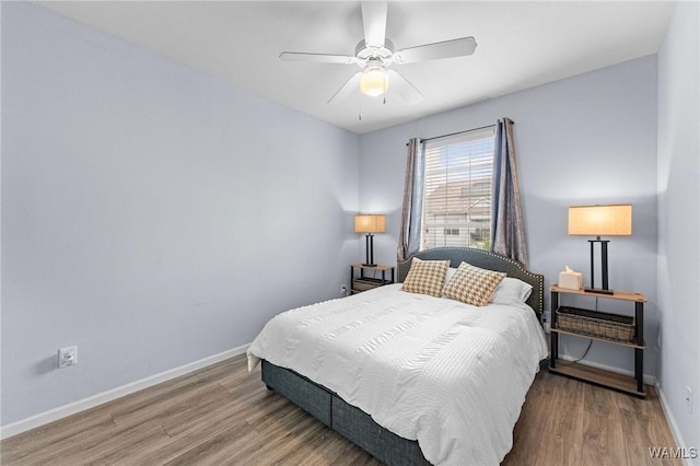 bedroom featuring ceiling fan, baseboards, and wood finished floors