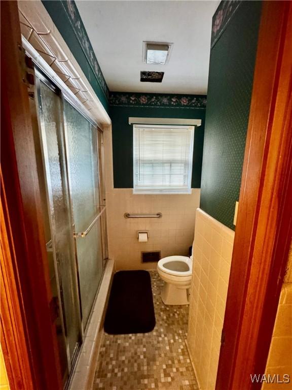 bathroom featuring an enclosed shower, tile patterned flooring, toilet, and tile walls