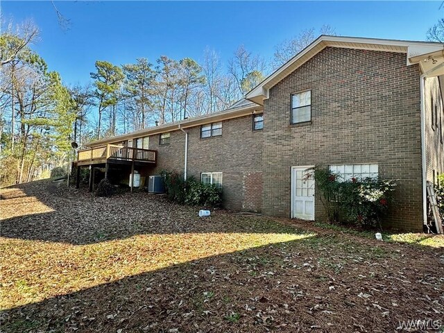 back of property featuring a wooden deck and cooling unit