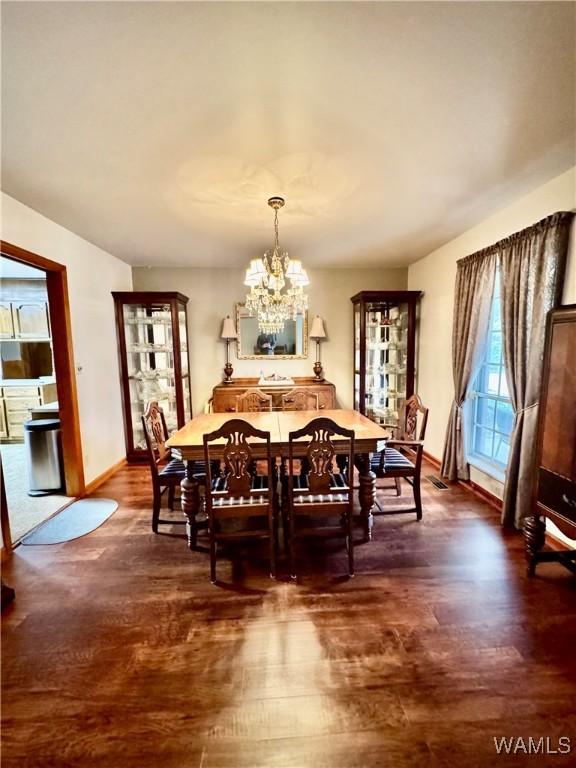 dining space featuring dark hardwood / wood-style flooring and a notable chandelier