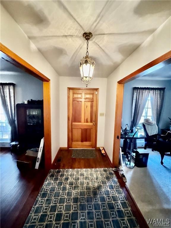 entrance foyer with dark hardwood / wood-style flooring and an inviting chandelier