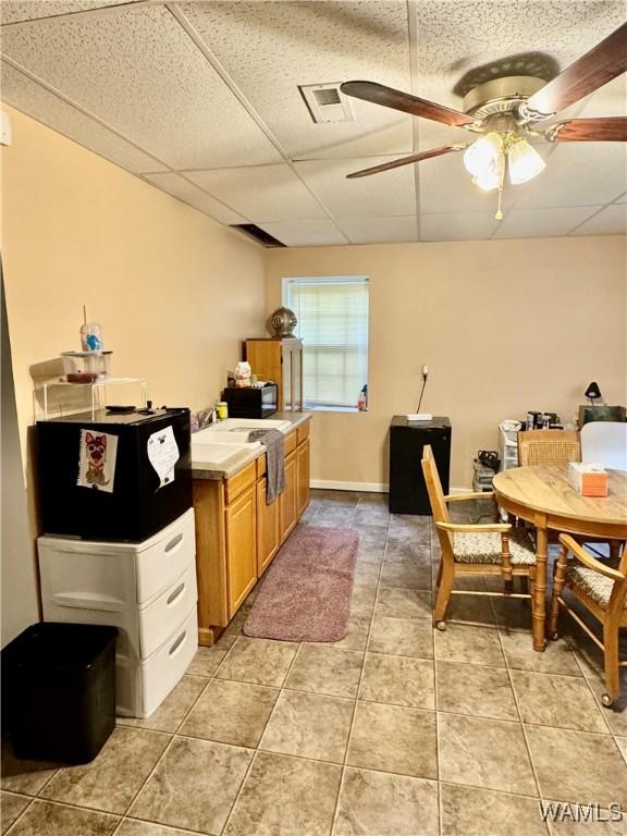 kitchen featuring a paneled ceiling, ceiling fan, and light tile patterned flooring