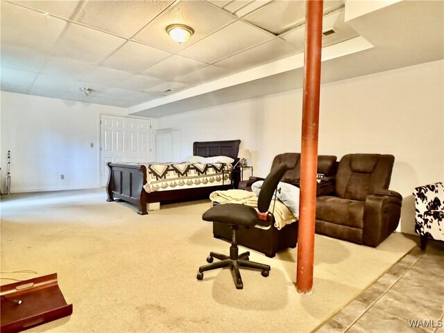 carpeted bedroom featuring a drop ceiling