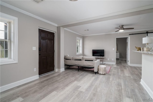 living room featuring ornamental molding, a barn door, ceiling fan, and light hardwood / wood-style flooring