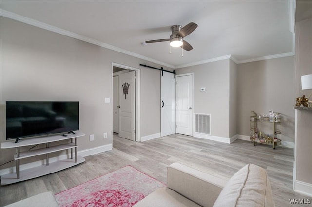 living room featuring ornamental molding, a barn door, ceiling fan, and light hardwood / wood-style floors