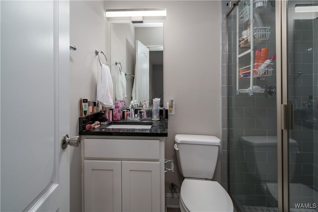 bathroom with walk in shower, vanity, and toilet