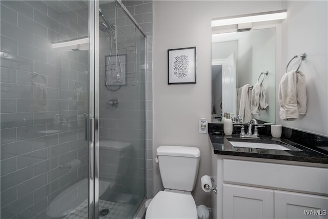 bathroom featuring walk in shower, vanity, and toilet