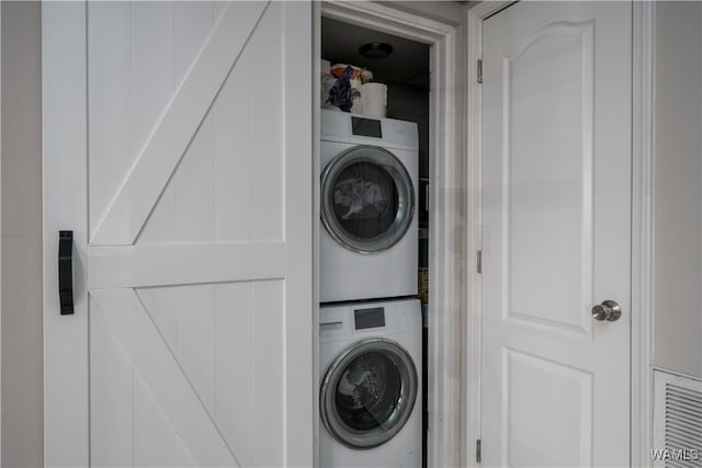 laundry area featuring stacked washer / drying machine