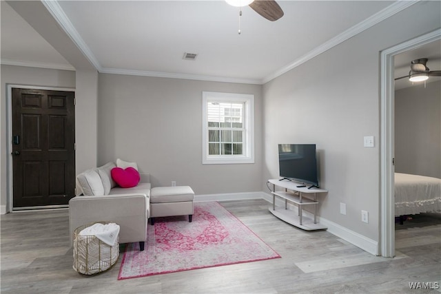 living area with crown molding, light wood-type flooring, and ceiling fan