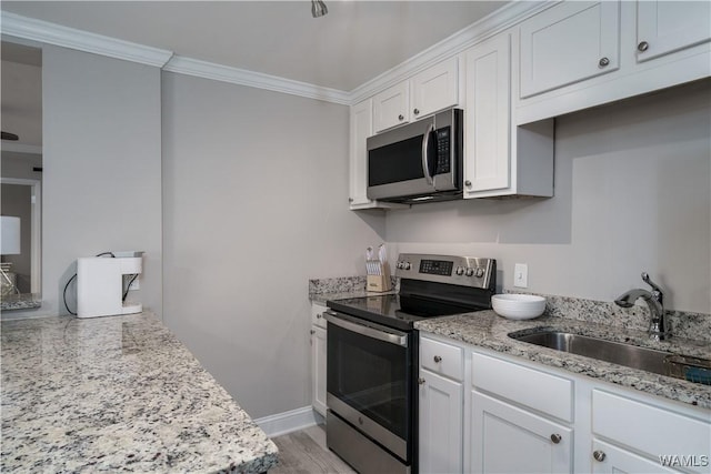 kitchen featuring white cabinetry, sink, ornamental molding, and appliances with stainless steel finishes