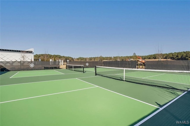 view of tennis court with fence and community basketball court