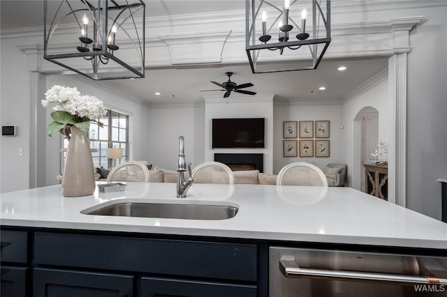 kitchen featuring stainless steel dishwasher, ornamental molding, open floor plan, light countertops, and a sink