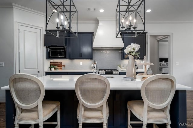 kitchen with light countertops, backsplash, an inviting chandelier, and custom range hood