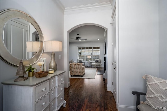 corridor featuring crown molding, baseboards, dark wood-type flooring, recessed lighting, and arched walkways