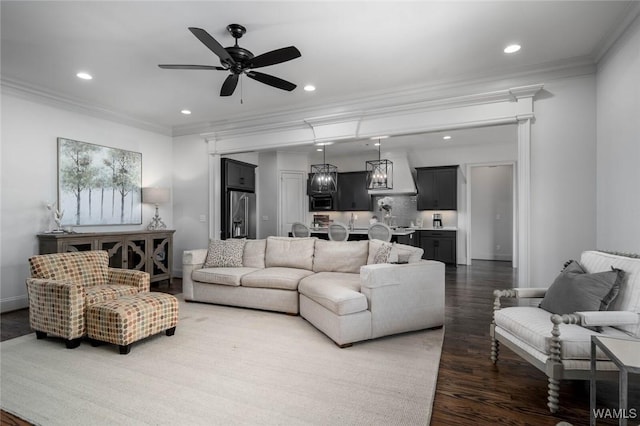 living room featuring ceiling fan, ornamental molding, recessed lighting, and wood finished floors