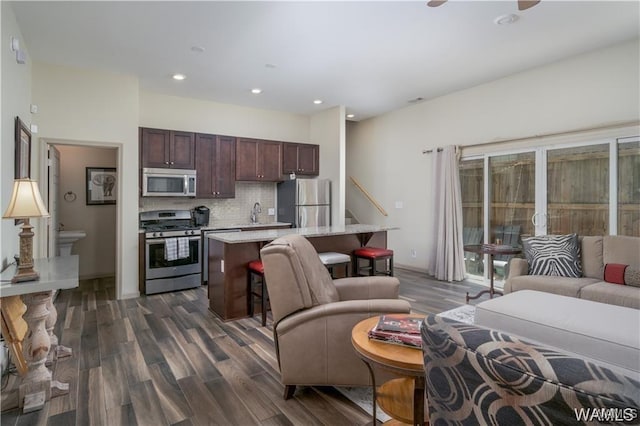 living room featuring recessed lighting, dark wood-type flooring, and a ceiling fan