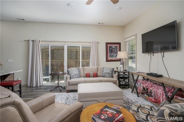 living room featuring wood finished floors, visible vents, and ceiling fan