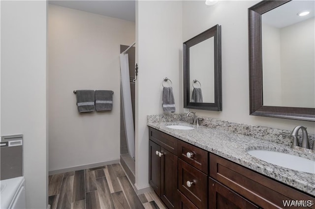702 Gene Stallings Ave, Tuscaloosa, AL 35401 - full bathroom with double vanity, wood finished floors, baseboards, and a sink
