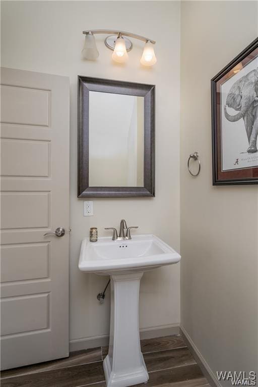 702 Gene Stallings Ave, Tuscaloosa, AL 35401 - bathroom featuring a sink, baseboards, and wood finished floors