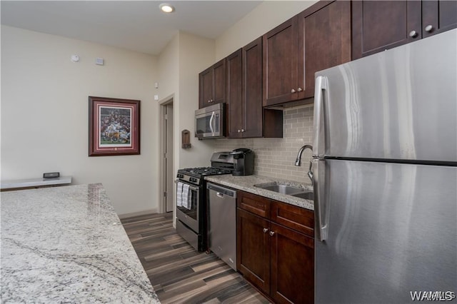 702 Gene Stallings Ave, Tuscaloosa, AL 35401 - kitchen with a sink, dark wood-style floors, dark brown cabinetry, appliances with stainless steel finishes, and decorative backsplash