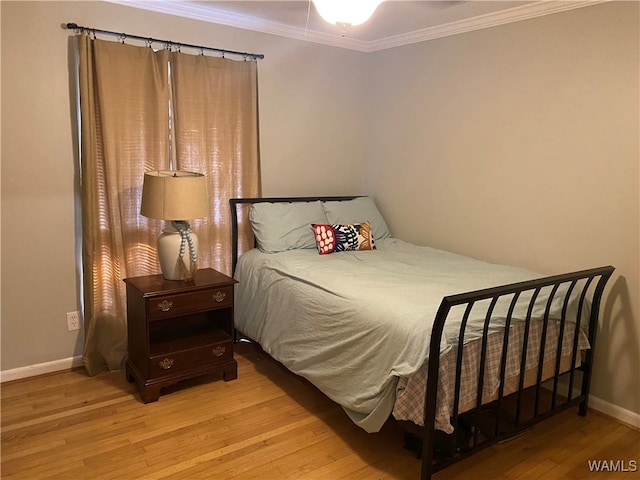 bedroom featuring light hardwood / wood-style flooring and crown molding