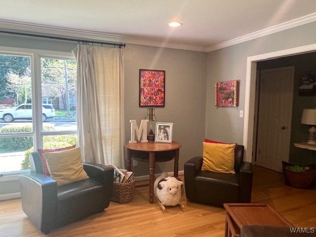 sitting room featuring wood-type flooring and ornamental molding